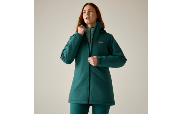 Person in a long green hooded coat, zipping the front; wearing green leggings; plain light background; looking up and to the right