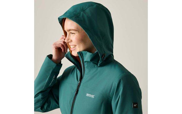 Person in profile, smiling with hand near face, wearing green hooded jacket with zipper and logo, light background