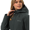 Frau mit langen blonden Haaren trägt eine dunkle Outdoor-Jacke mit Kapuze