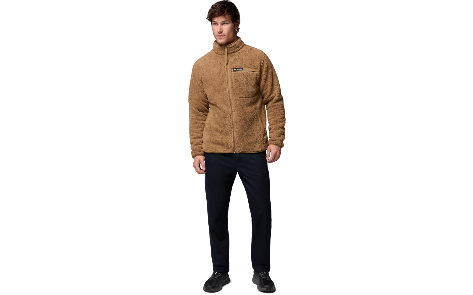 Mann trägt eine braune Jacke und schwarze Hose, steht frontal