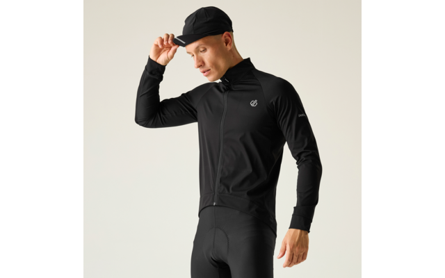Persona con abbigliamento da ciclismo nero e berretto, sistema il berretto con la mano destra