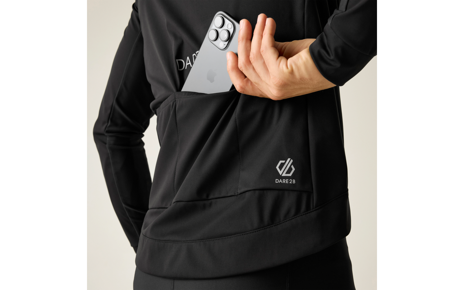 Persona con giacca sportiva nera inserisce uno smartphone nella tasca posteriore; logo DARE 28 visibile