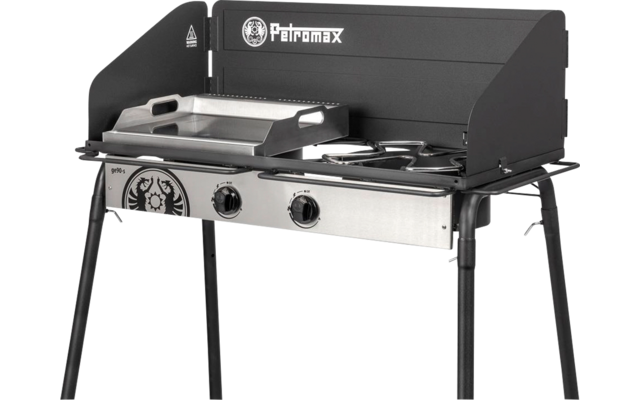 Réchaud/gril de camping noir avec pare-vent, façade en acier inoxydable, deux boutons de commande, plaque de cuisson à gauche, deux brûleurs ronds à droite, logo Petromax