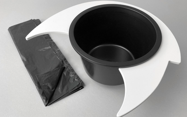 Chapeau noir avec casque blanc et feuille de plastique noire pliée sur une surface grise