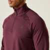 Man draagt een bordeauxkleurig sportshirt met lange mouwen en een rits bij de kraag