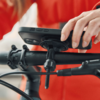 Hand hält Smartphone in einer Halterung am Fahrradlenker