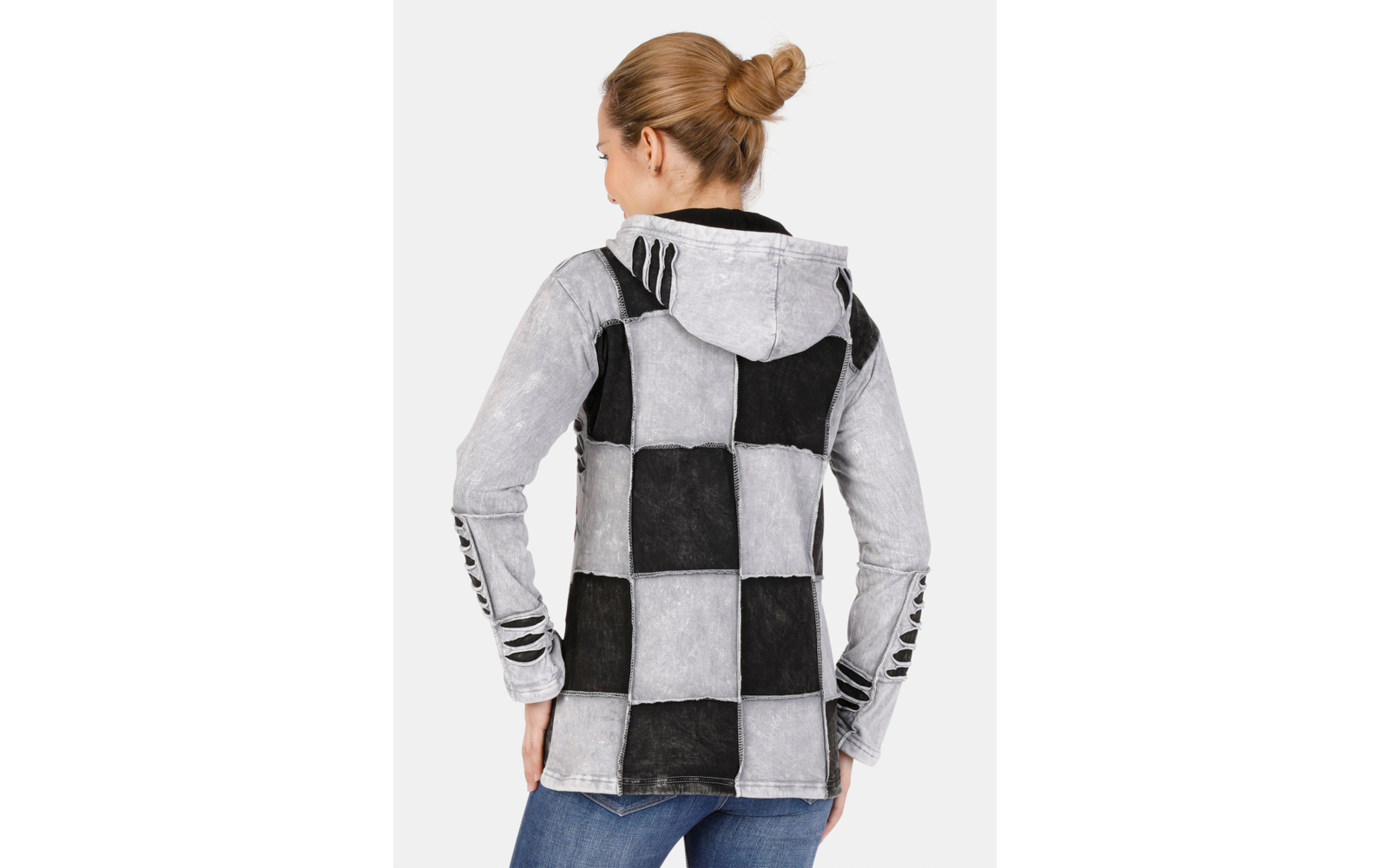 Rückansicht einer Person mit hochgestecktem Haar, die einen Kapuzenpullover mit großem schwarz-grau kariertem Muster und Jeans trägt, vor hellem Hintergrund