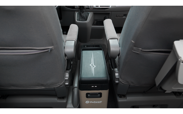 Blick zwischen zwei grauen Vordersitzen auf eine mittige Konsole mit rechteckigem gepolstertem Aufsatz und heruntergeklappten Armlehnen; auf dem Aufsatz ein weißes Sternsymbol