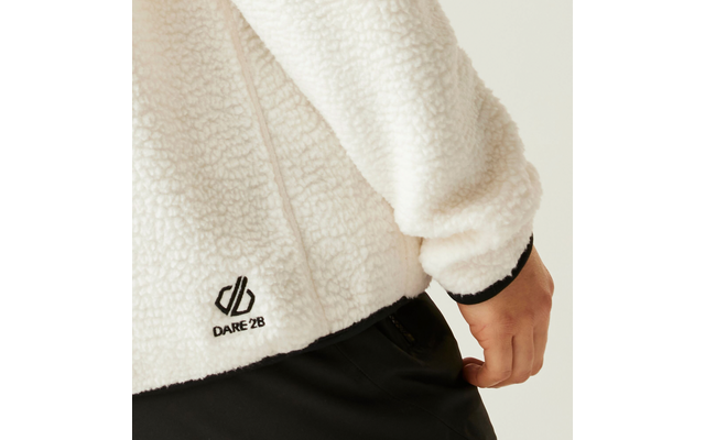 Weißer Fleecepullover mit schwarzem Logo am unteren Ärmel, Hand im Hosentasche