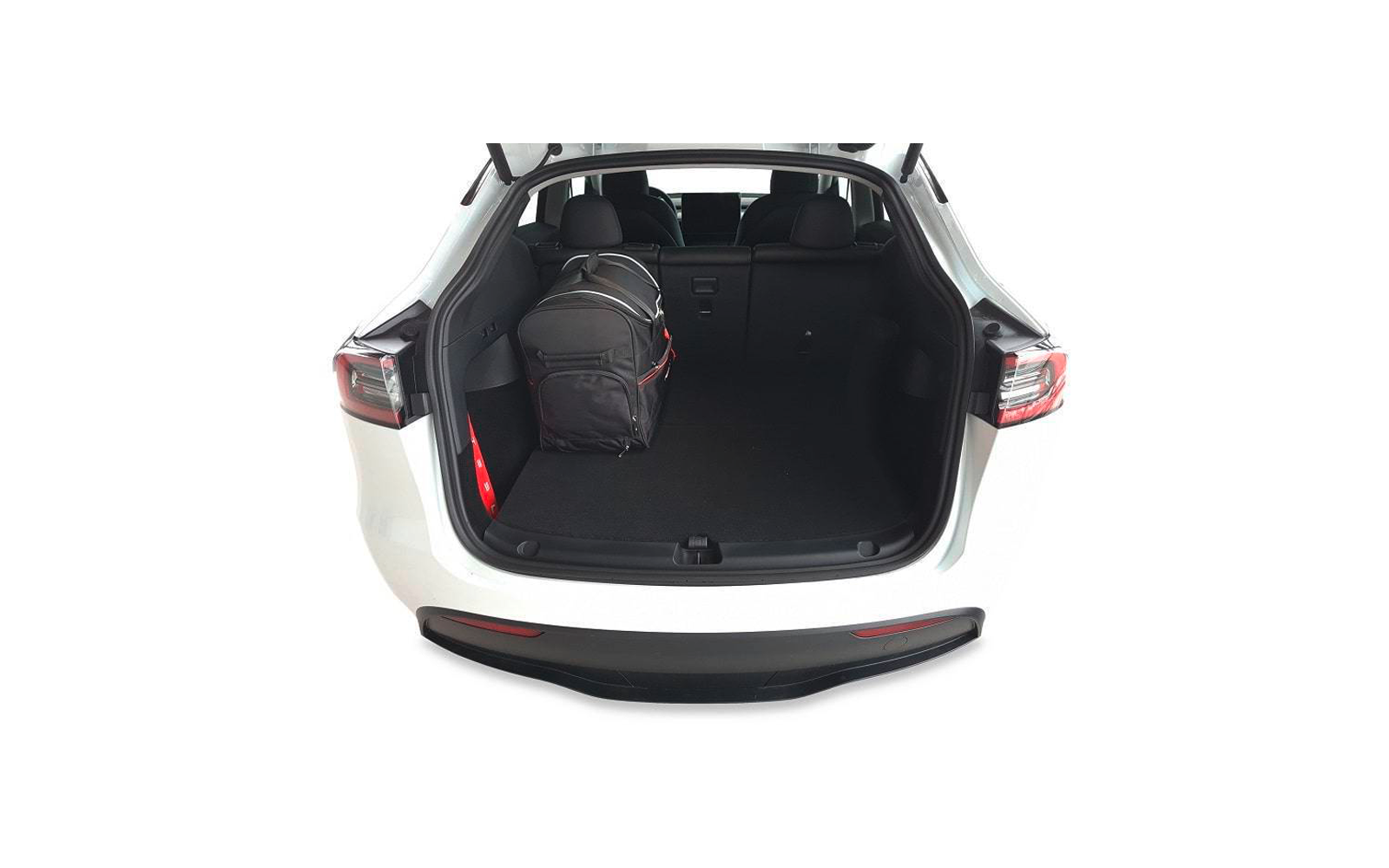 Coffre ouvert d'une voiture blanche, sac à dos noir à gauche, sièges arrière avec appuie-têtes visibles