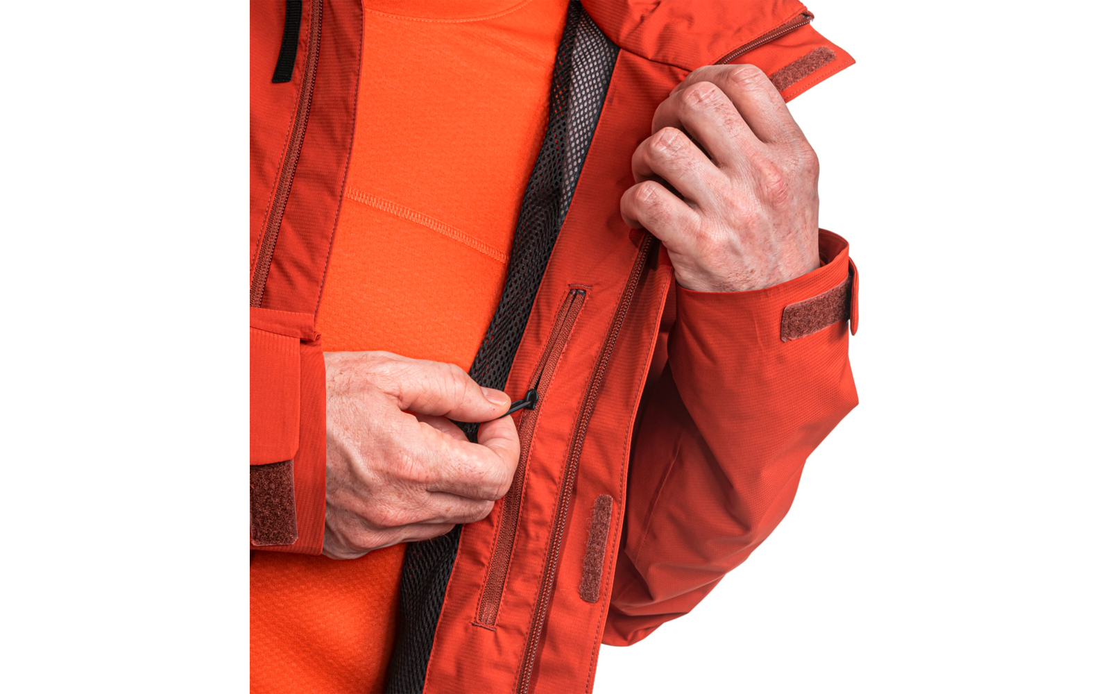 Nahaufnahme von Händen, die einen Reißverschluss an der Innentasche einer orangefarbenen Jacke schließen