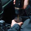 Kaffee wird aus einer Kaffeemaschine in einen Becher gegossen