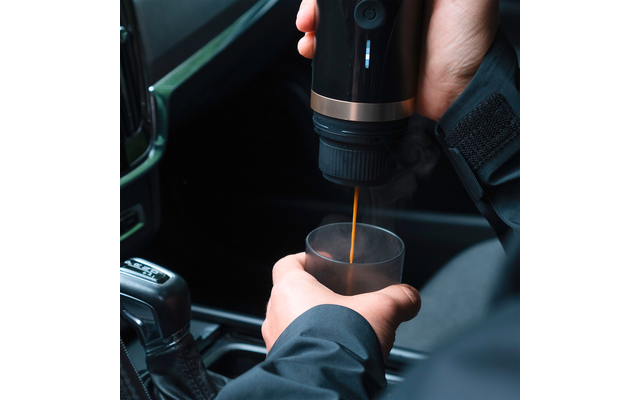 Kaffee wird aus einer Kaffeemaschine in einen Becher gegossen