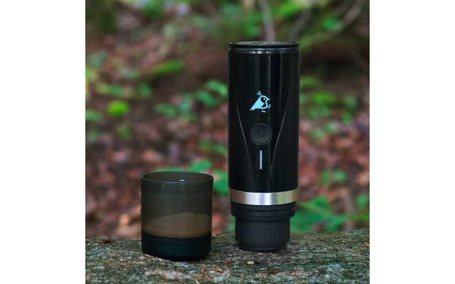 Schwarzer Trinkbecher und schwarze Dose stehen nebeneinander auf einem Stein im Wald