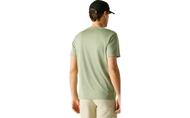 Person von hinten trägt hellgrünes T‑Shirt, helle Shorts und schwarze Kappe vor hellem einfarbigem Hintergrund