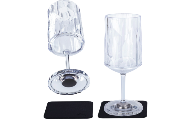 Two clear wine glasses with faceted design, one standing and one lying on its side, each on a black coaster