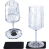 Two clear wine glasses with faceted design, one standing and one lying on its side, each on a black coaster