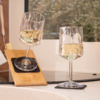Wine glass with orange-red drink on the deck of a sailboat, trampoline netting, ropes, rigging and open sea in the background