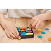 Mains d'enfants jouant avec un jeu de logique coloré sur une table en bois