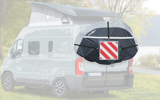 Retro di un camper bianco con portellone posteriore aperto, con una borsa per biciclette nera con un triangolo di segnalazione rosso e bianco attaccato
