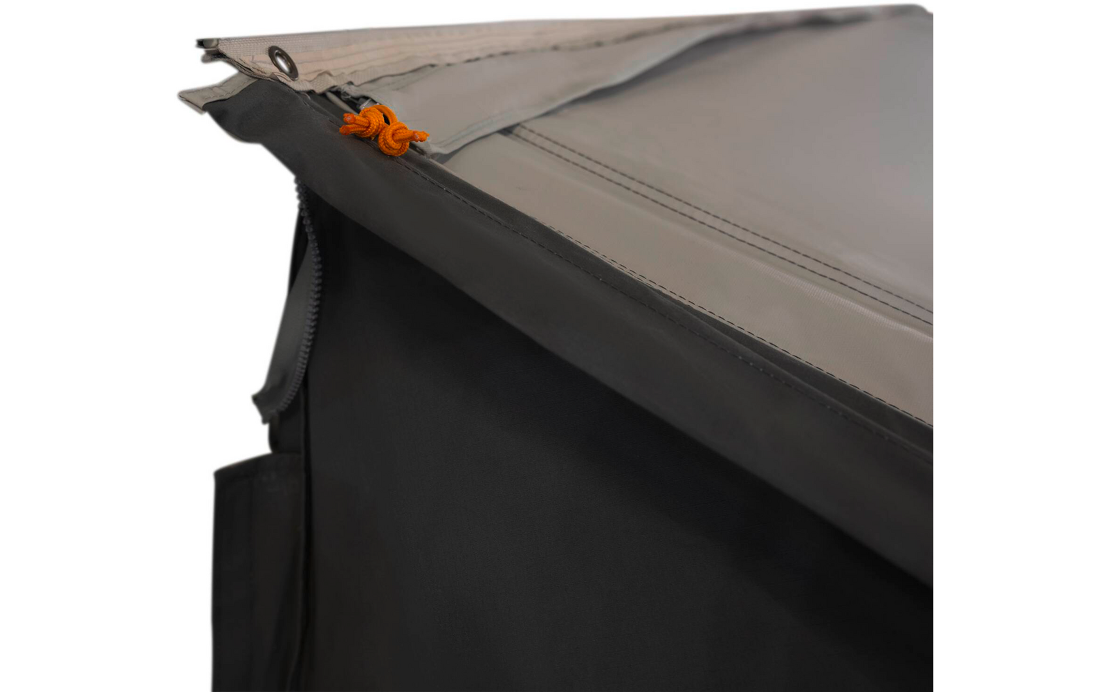 Nahaufnahme von überlappenden grauen und schwarzen Stoffbahnen mit sichtbaren Nähten, einem Reißverschluss an der Seite und einer orangefarbenen Schnur durch eine Metallöse