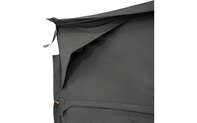 Dark grey fabric with a folded overlapping flap at top left, visible seams, and a zipper with an orange pull tab at bottom left