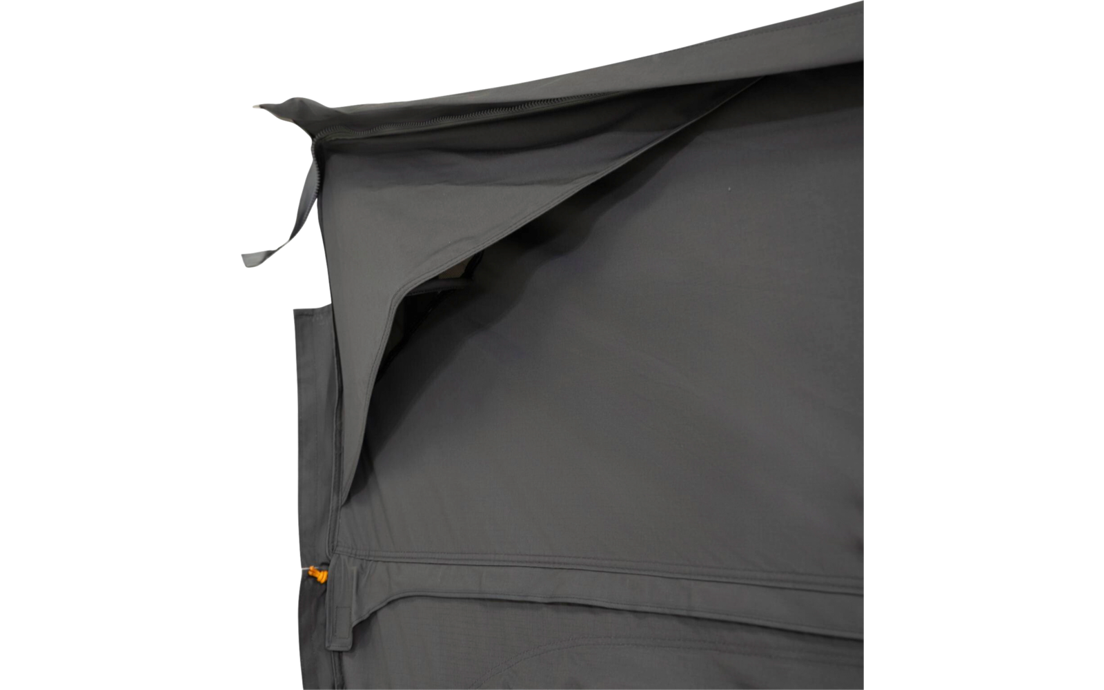 Dark grey fabric with a folded overlapping flap at top left, visible seams, and a zipper with an orange pull tab at bottom left