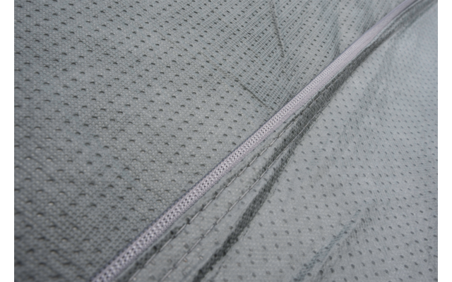 Close-up of light gray fabric with fine dotted texture and a visible zipper
