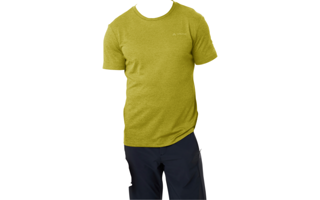 Staande persoon met kort haar, groen T-shirt en donkere broek, één hand in de zak, andere hand naast het lichaam, witte achtergrond