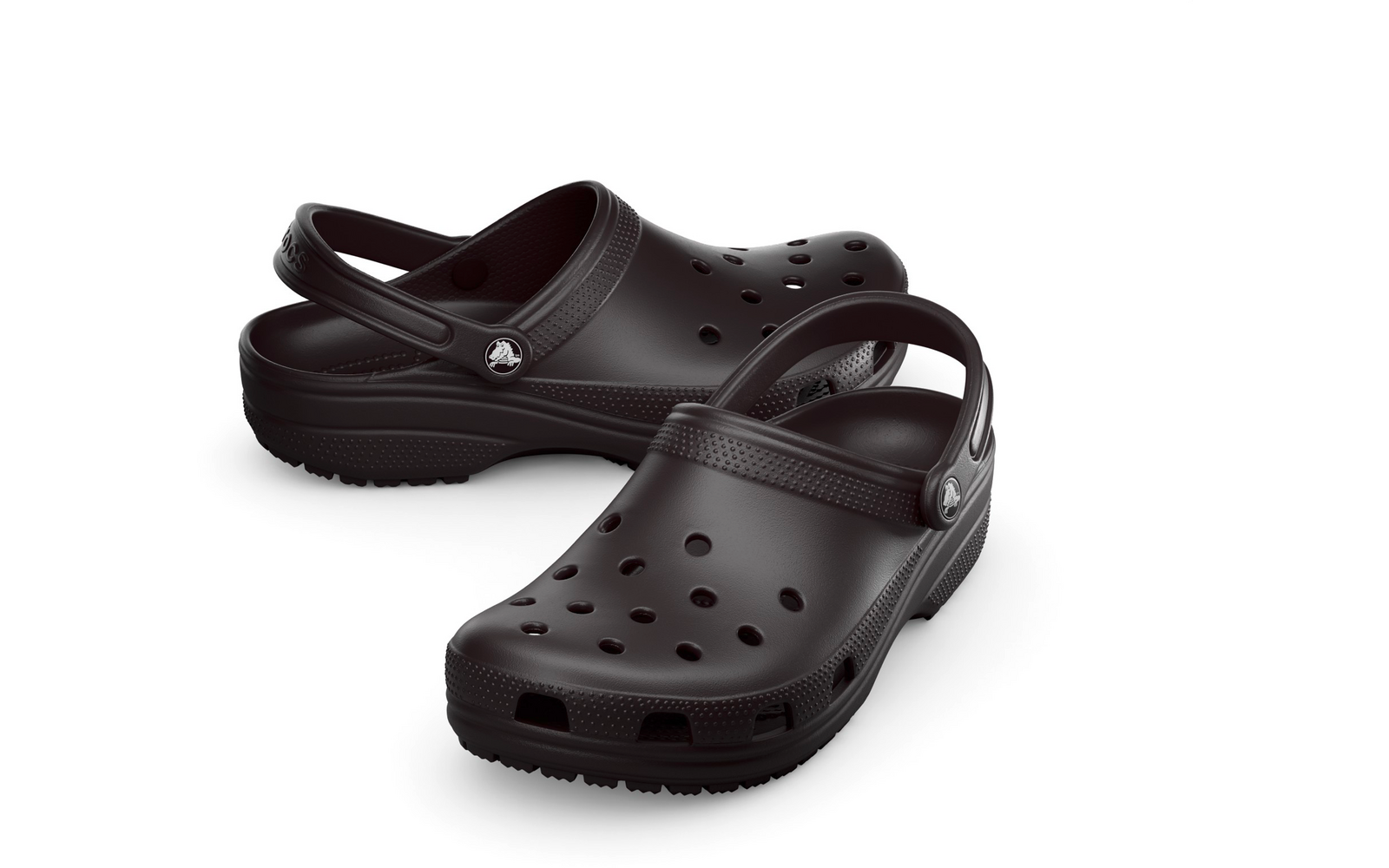 Ein Paar schwarze Clogs mit verstellbaren Fersenriemen und runden Belüftungsöffnungen auf weißem Hintergrund