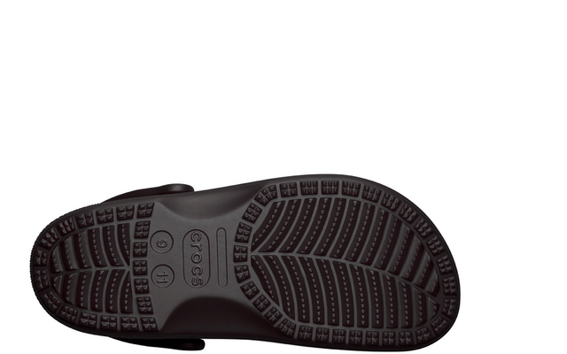 Unterseite eines dunklen Gummischuhs mit Fersenriemen, Profil mit Noppen und Rillen