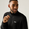 Man with short hair and beard wearing a black fleece pullover pulls the zipper and looks to the side