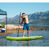 Mann auf Stand-Up-Paddle-Board auf ruhigem Wasser mit Bergen im Hintergrund