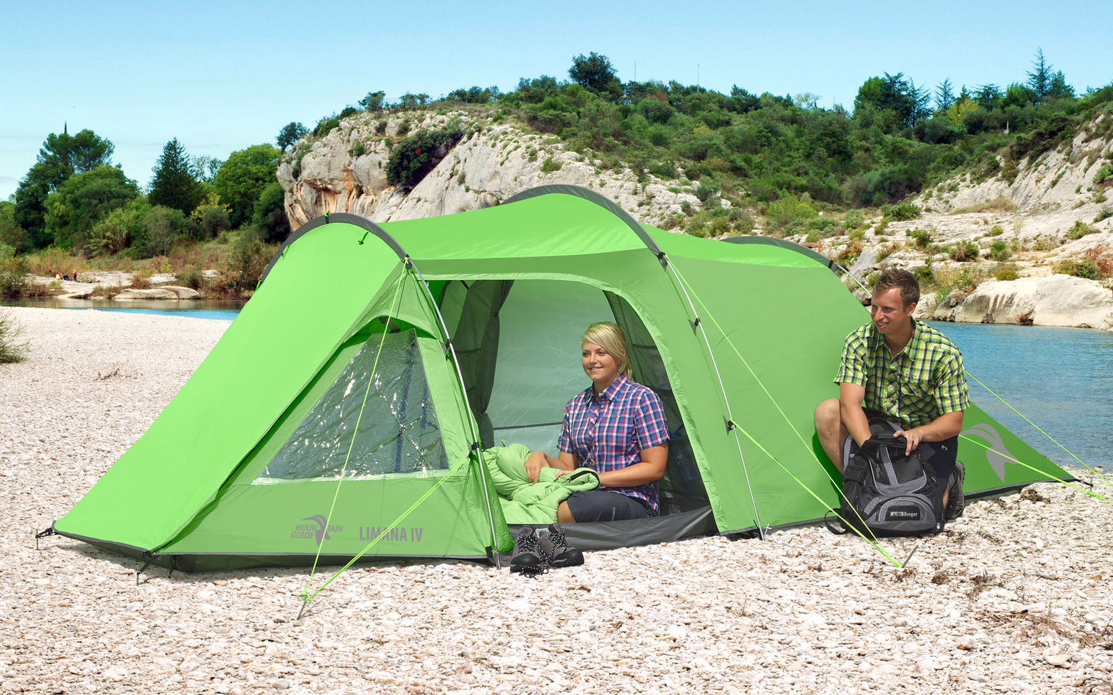 Zwei Männer sitzen neben einem grünen Zelt auf einem steinigen Flussufer