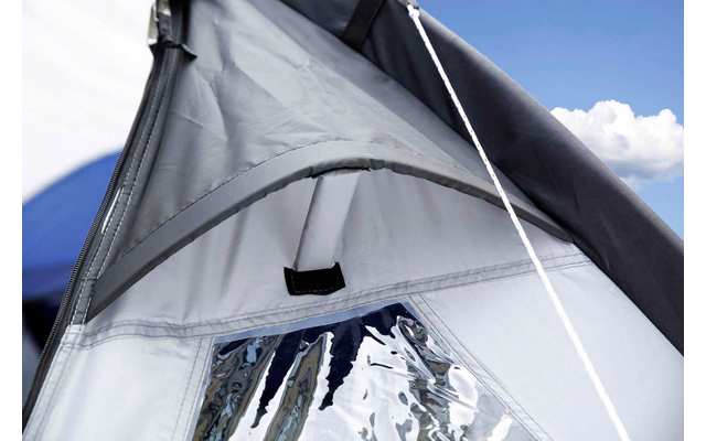 Primo piano del tetto di una tenda aperta e del tessuto della tenda contro un cielo azzurro con nuvole