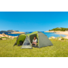 Grüne Zelt auf einer Wiese am Meer, eine Person sitzt vor dem Zelt