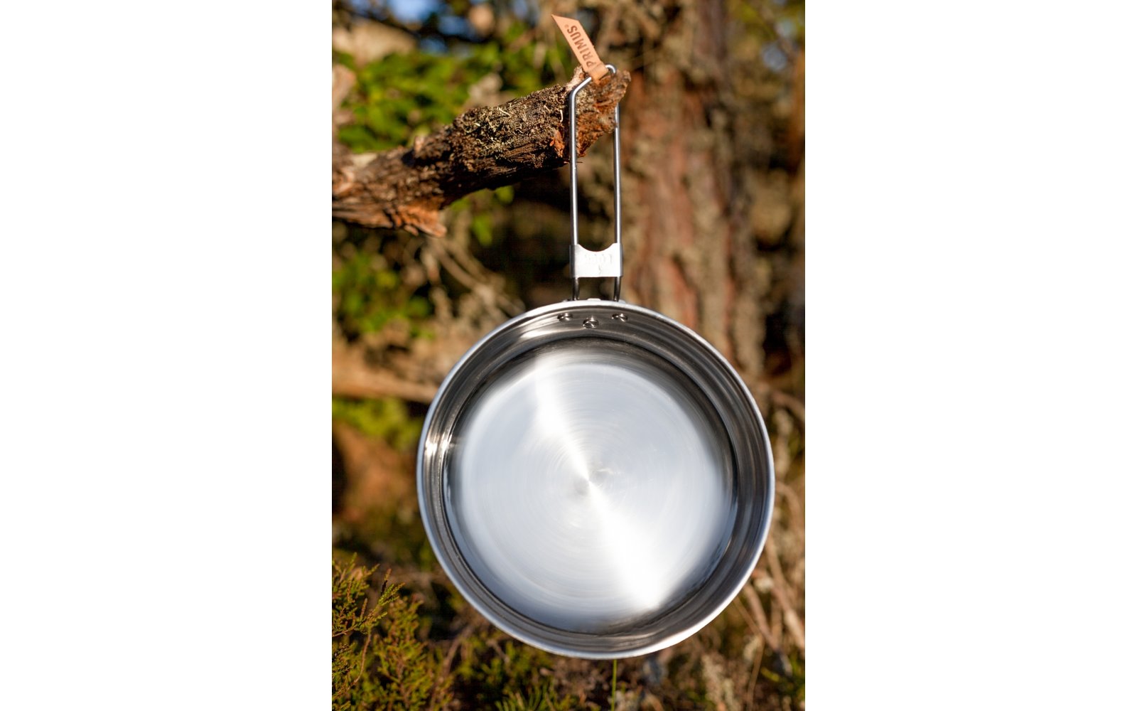 Zwei Männer spielen Schach an einem Holztisch im Freien, umgeben von grünen Pflanzen