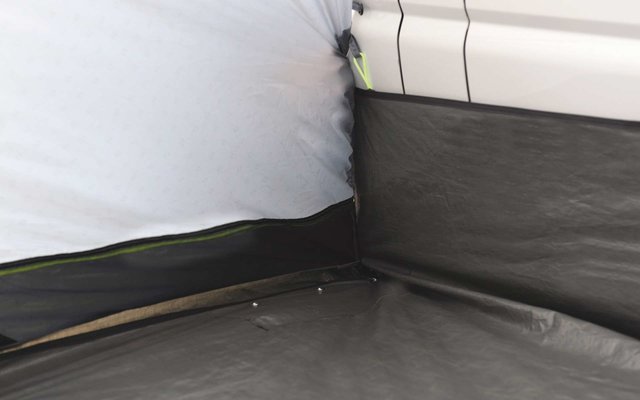 Ecke eines Zimmers mit weißer Wand und schwarzem Bodenbelag