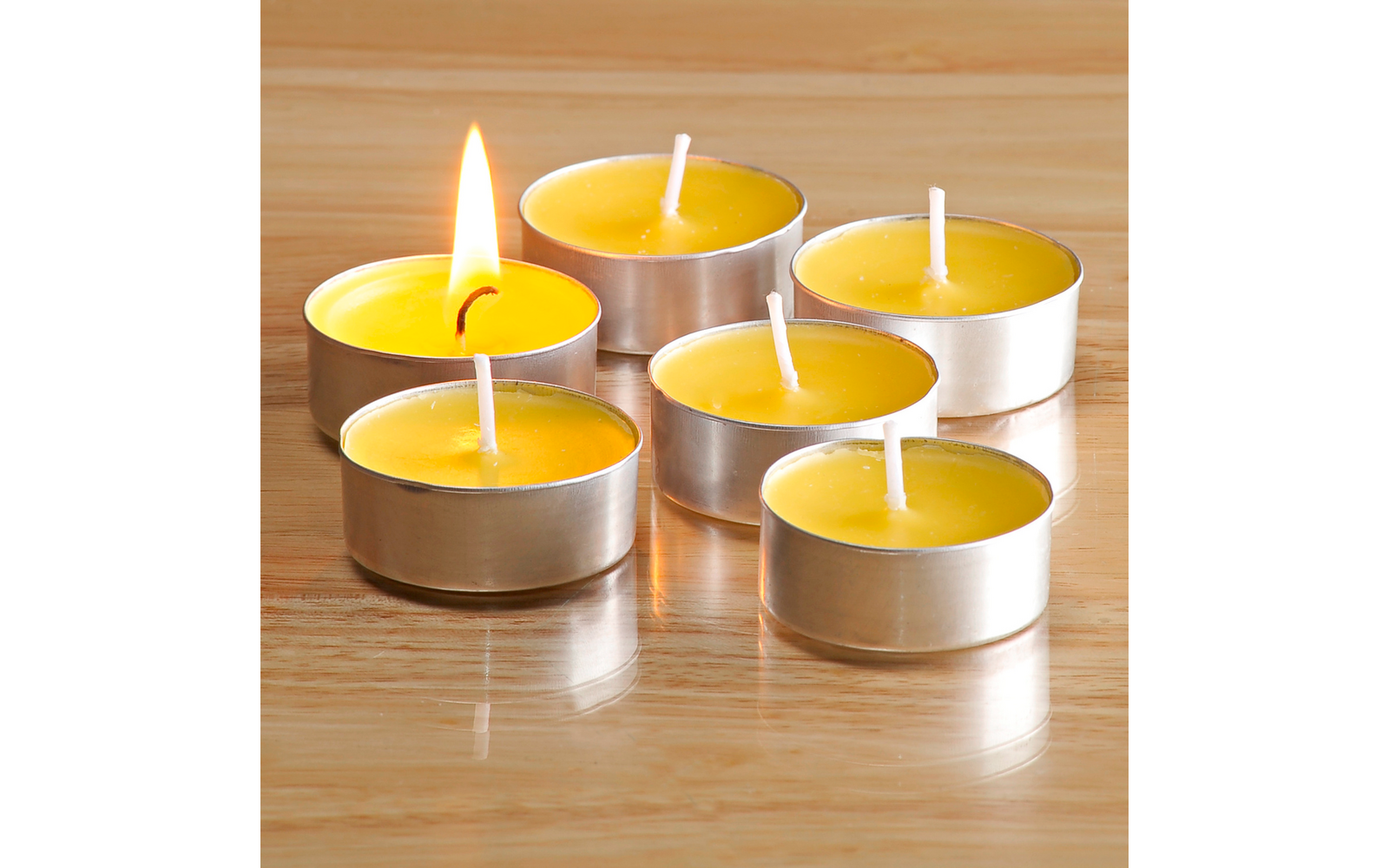 Five yellow tealight candles, one is lit