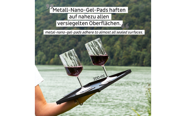Two glasses of red wine on a sailboat with water and forest in the background