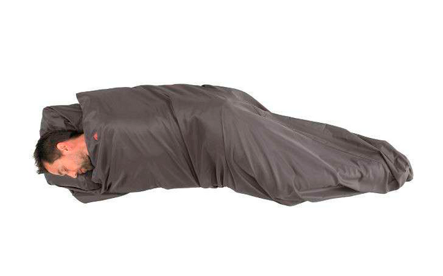 Eine Person liegt eingewickelt in einem dunkelgrauen Schlafsack