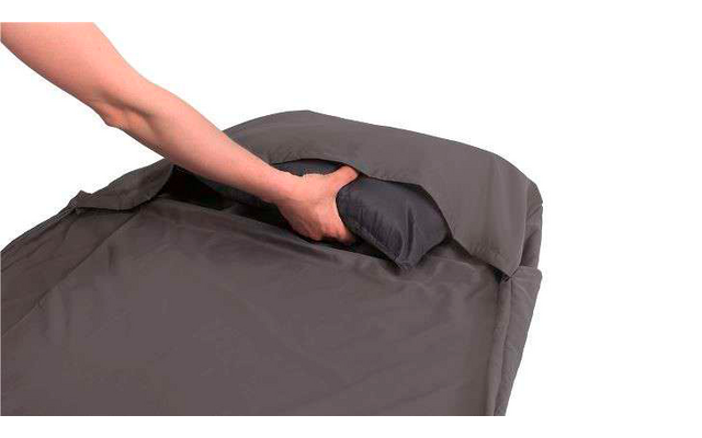 Hand steckt ein Kissen in einen grauen Kissenbezug