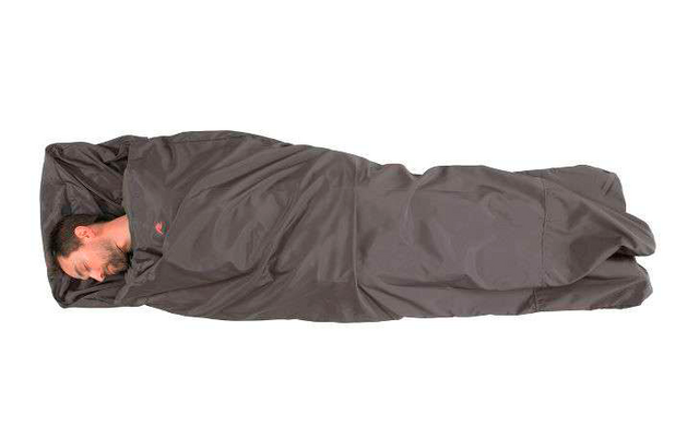 Person liegt in einem grauen Schlafsack