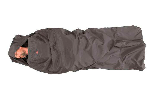 Person schläft eingewickelt in einen dunklen Schlafsack