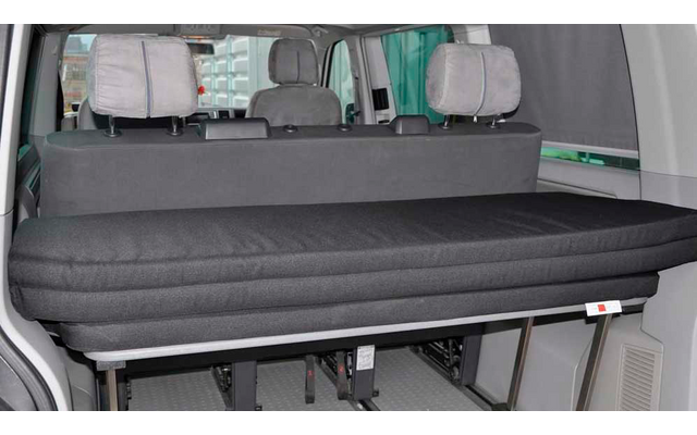 Black folding bed inside a vehicle with three headrests in the background