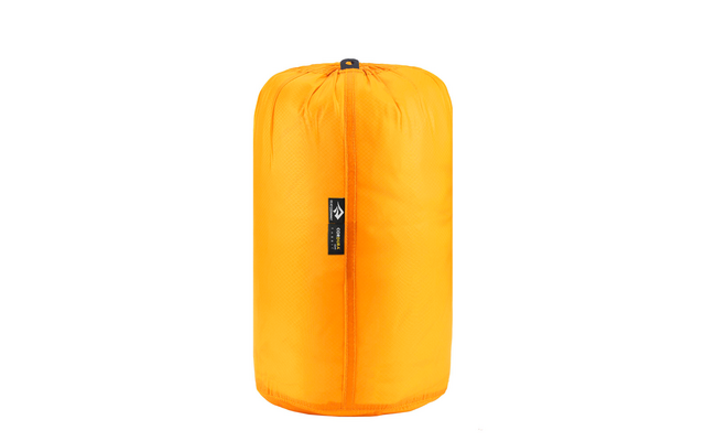 Oranger Schlafsack in einer Verpackungstasche auf weißem Hintergrund