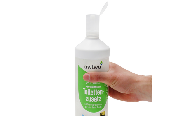 Hand hält weiße Flasche mit grünem Etikett und Schriftzug Toilettenzusatz