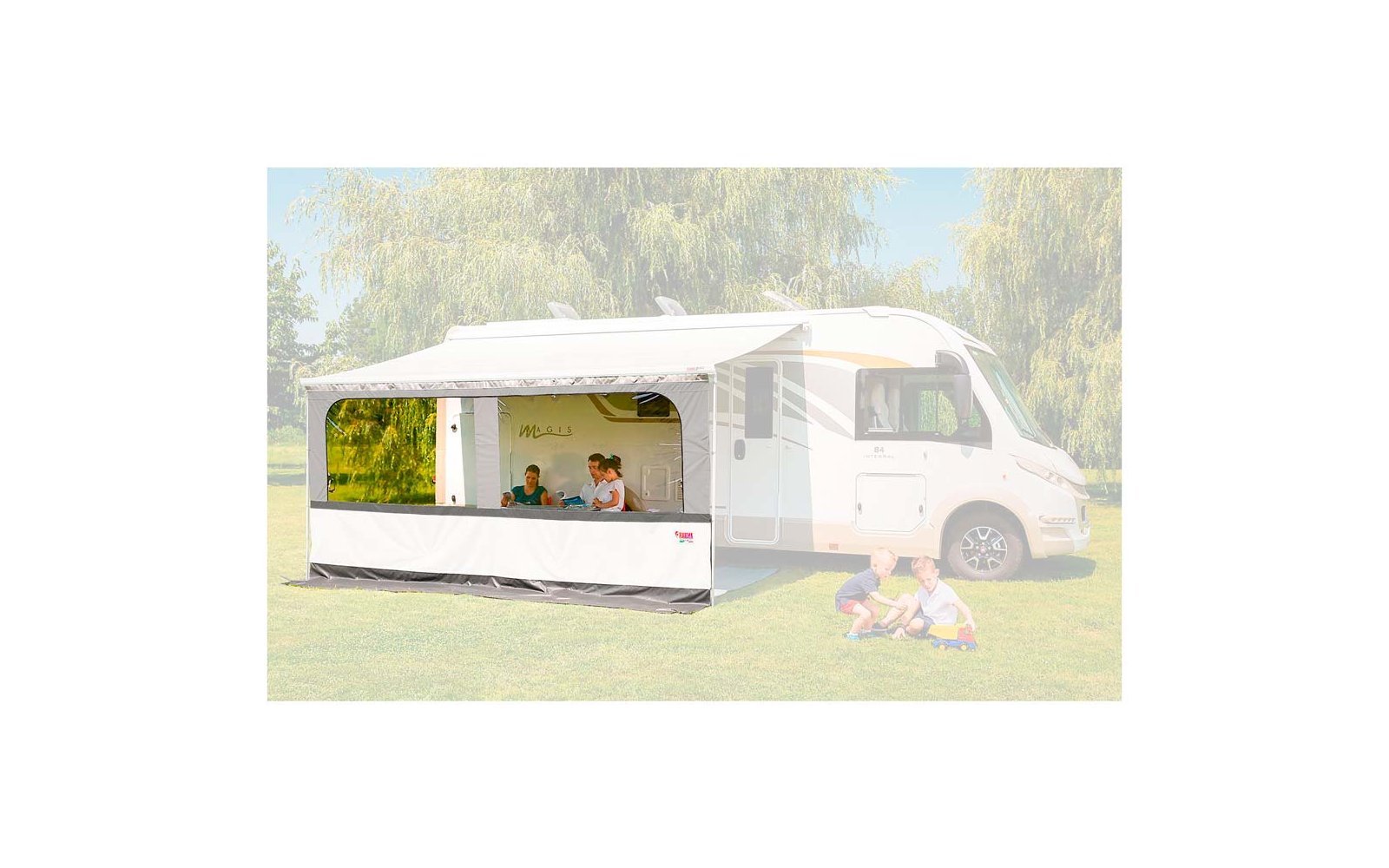 Weißes Wohnmobil auf einem grünen Feld mit Bäumen im Hintergrund, davor sitzt eine Person auf einer Decke