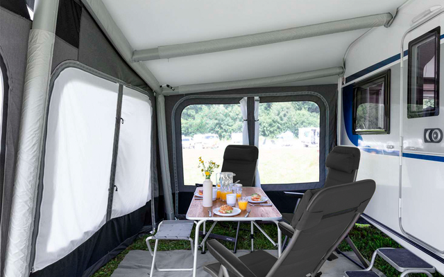 Interior of a camper with table, chairs, and door view