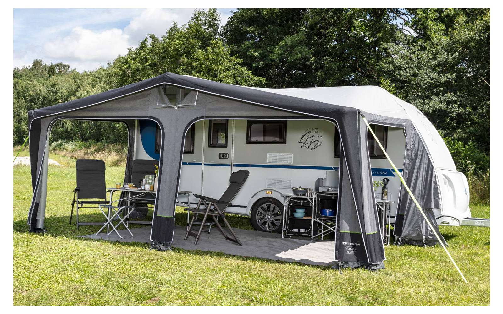 Caravan with awning on green grass under blue sky